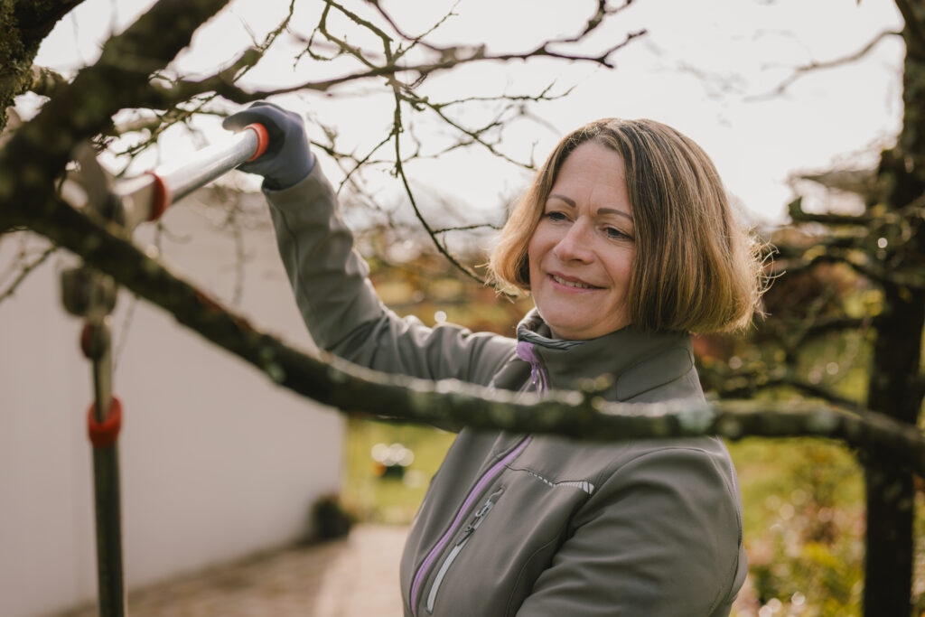 Ina Krone, Kandidatin für die Bürgermeisterwahl Pfedelbach, schneidet einen Obstbaum in ihrem Garten in Pfedelbach.